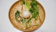 ざるに並べた春の七草と小さなかぶ