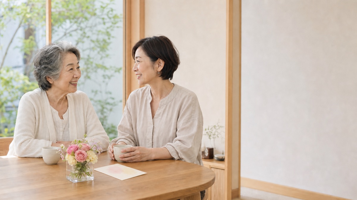 敬老の日に母娘が小さな花とカードを囲んで話すイメージ