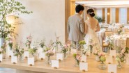 結婚式の受付に花と白いエスコートカードを並べるイメージ