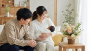 赤ちゃんを抱く夫婦と自宅に届いた花の贈り物