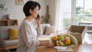祖父母へ電話をかけながら花ギフトを準備する家族
