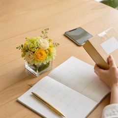 カレンダーと荷物を見ながら花ギフトの到着日を確認する様子